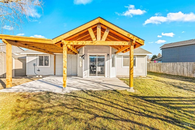 rear view of property with a patio, a yard, and fence