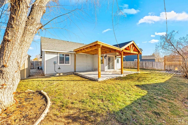 back of property with a yard, a patio area, and a fenced backyard