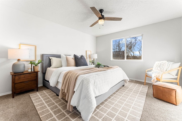 bedroom featuring light carpet, a ceiling fan, baseboards, and a textured ceiling