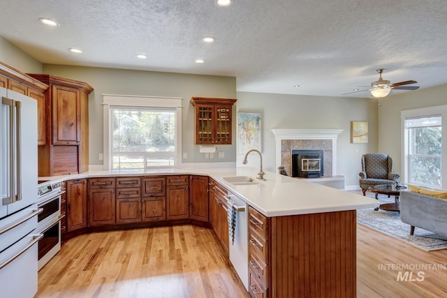 16089 N Basin Way, Boise, ID 83714 - kitchen featuring a sink, appliances with stainless steel finishes, open floor plan, a textured ceiling, and a peninsula