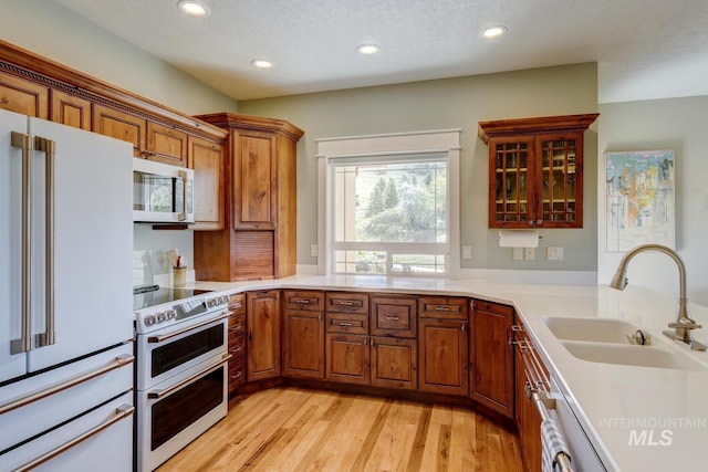 16089 N Basin Way, Boise, ID 83714 - kitchen featuring white appliances, a sink, recessed lighting, brown cabinetry, and light wood-style floors