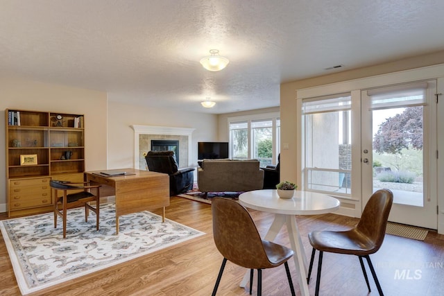 16089 N Basin Way, Boise, ID 83714 - dining area with a textured ceiling, light wood-type flooring, and a tiled fireplace