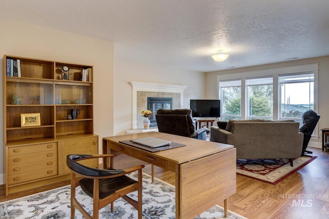 16089 N Basin Way, Boise, ID 83714 - office area featuring wood finished floors, a textured ceiling, and a tile fireplace