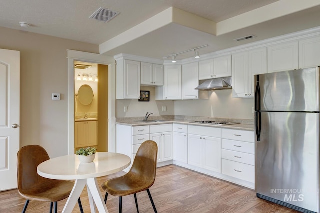 16089 N Basin Way, Boise, ID 83714 - kitchen featuring freestanding refrigerator, under cabinet range hood, white stovetop, white cabinets, and light countertops