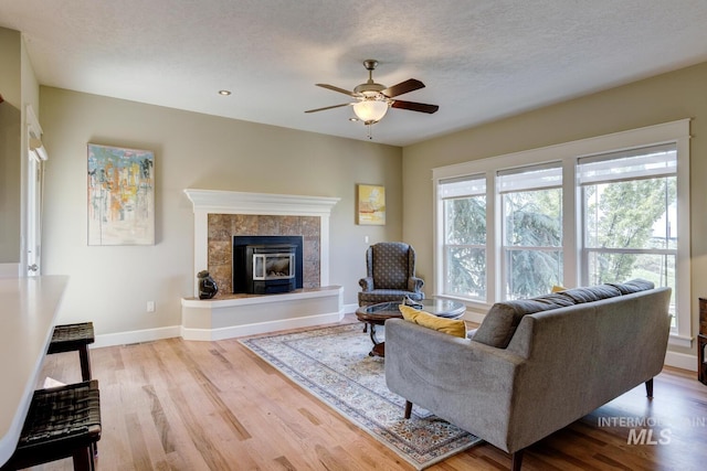 16089 N Basin Way, Boise, ID 83714 - living room with ceiling fan, wood finished floors, a tile fireplace, and baseboards