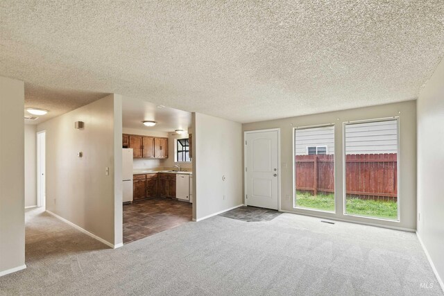 10397 10399 W Irving Ct, Boise, ID 83704 - unfurnished living room featuring baseboards, dark colored carpet, a sink, and a textured ceiling