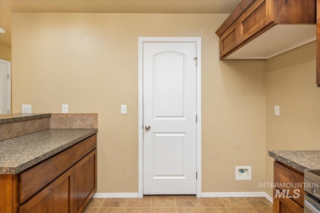 kitchen with dark countertops, brown cabinets, and baseboards