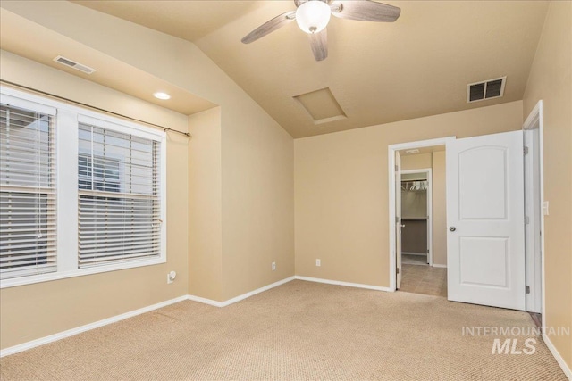 unfurnished bedroom featuring attic access, vaulted ceiling, visible vents, and light carpet