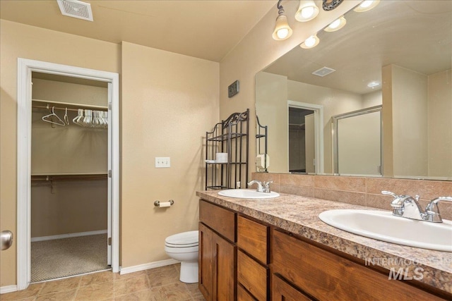 bathroom with a sink, visible vents, toilet, and a shower stall