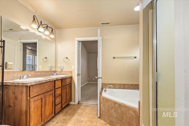 full bath featuring double vanity, a bath, visible vents, and a sink