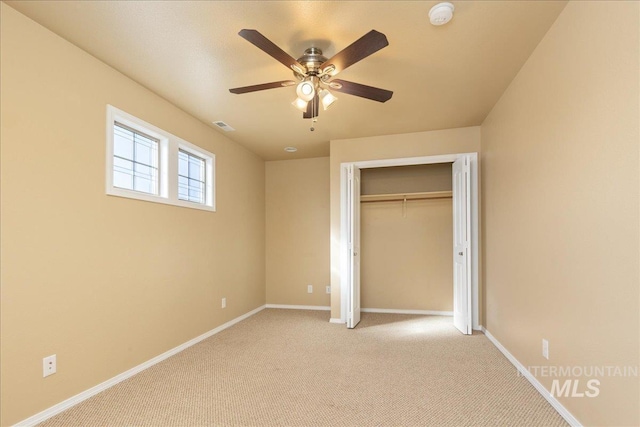 unfurnished bedroom featuring visible vents, baseboards, light colored carpet, and a closet