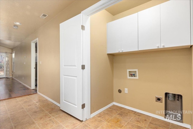 laundry area featuring hookup for a washing machine, visible vents, hookup for an electric dryer, baseboards, and cabinet space