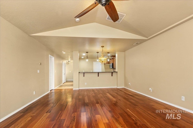 unfurnished living room with wood finished floors, visible vents, baseboards, lofted ceiling, and ceiling fan