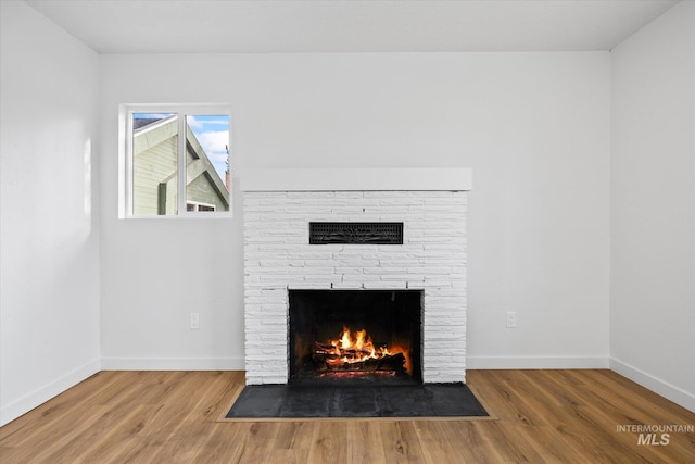 details with hardwood / wood-style flooring and a fireplace