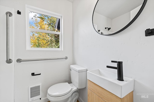 bathroom with vanity, toilet, and heating unit