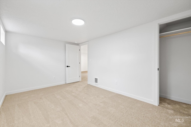 unfurnished bedroom with a closet and light colored carpet