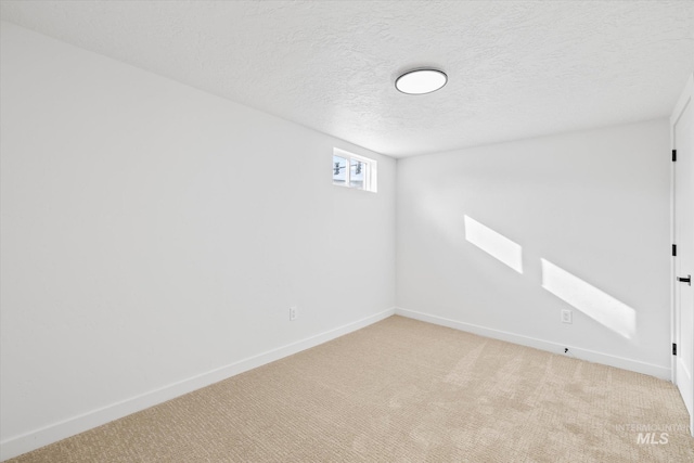 basement with a textured ceiling and light colored carpet