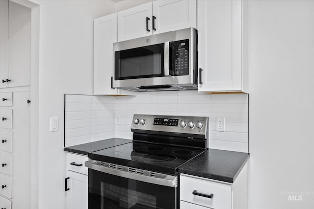 kitchen with stainless steel appliances, decorative backsplash, and white cabinets