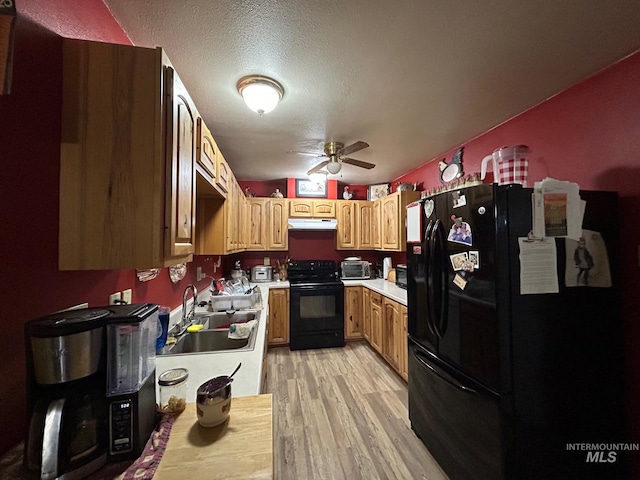 1585 Woodside Rd, Winchester, ID 83555 - kitchen featuring black appliances, a sink, under cabinet range hood, light countertops, and light wood-style flooring