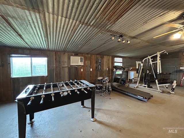 1585 Woodside Rd, Winchester, ID 83555 - rec room with a wall unit AC, concrete flooring, ceiling fan, and wood walls