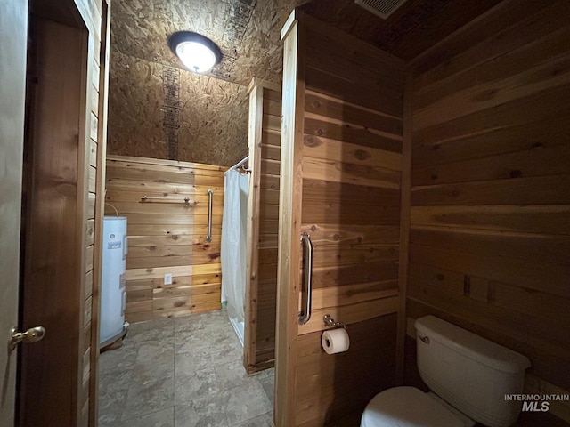 1585 Woodside Rd, Winchester, ID 83555 - bathroom with water heater, toilet, stone finish floors, wood walls, and a shower with curtain