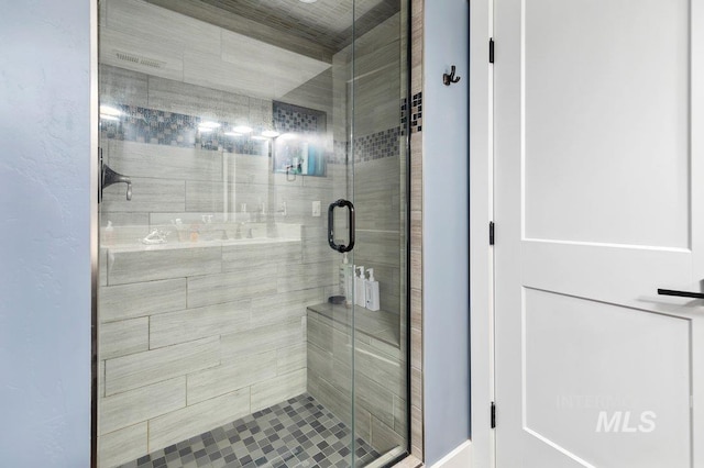 bathroom featuring a shower with shower door