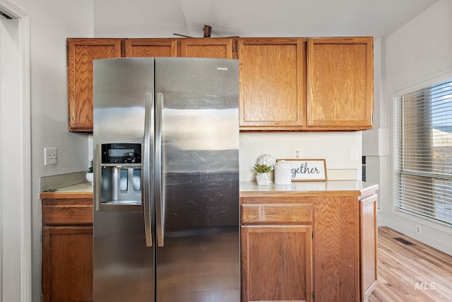 kitchen featuring stainless steel fridge with ice dispenser and light wood-type flooring