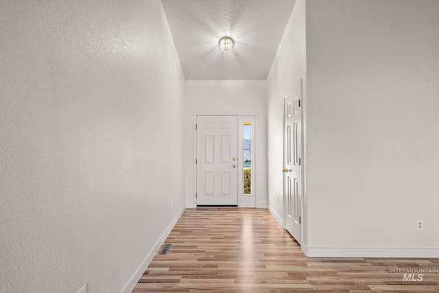 foyer with a textured ceiling and light wood-type flooring