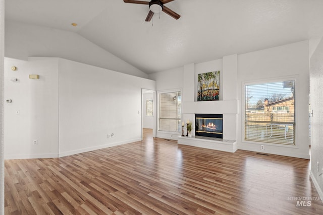 unfurnished living room featuring hardwood / wood-style flooring, vaulted ceiling, and ceiling fan