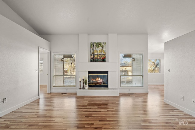 unfurnished living room featuring a healthy amount of sunlight and light hardwood / wood-style floors