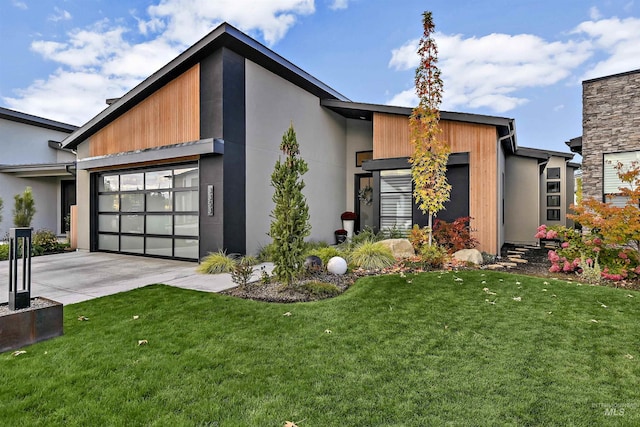 contemporary home with stucco siding, driveway, a front lawn, and an attached garage