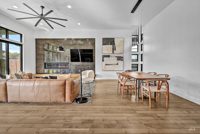 living area with a ceiling fan, recessed lighting, wood finished floors, and baseboards