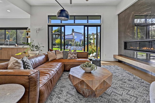 living area with wood finished floors, recessed lighting, a fireplace, and baseboards