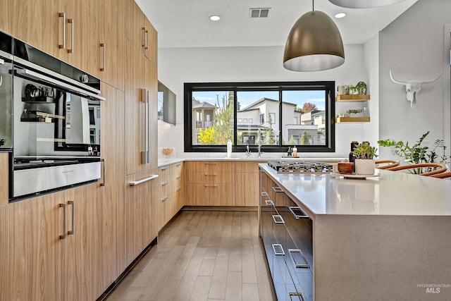 kitchen featuring stainless steel gas cooktop, visible vents, modern cabinets, and light countertops