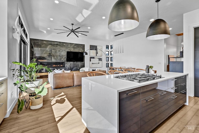 kitchen with light wood finished floors, modern cabinets, recessed lighting, stainless steel gas stovetop, and light countertops