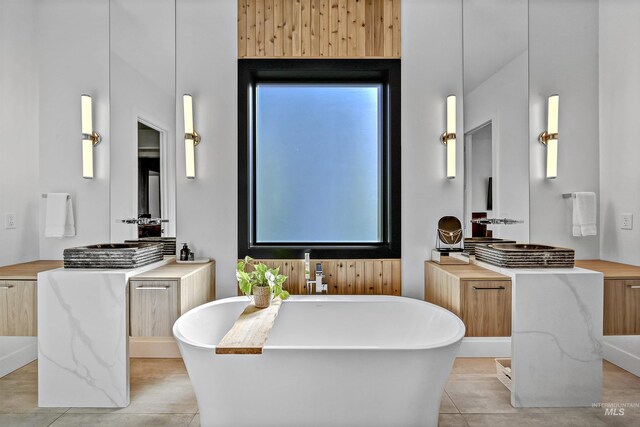 bathroom featuring tile patterned floors and a freestanding tub