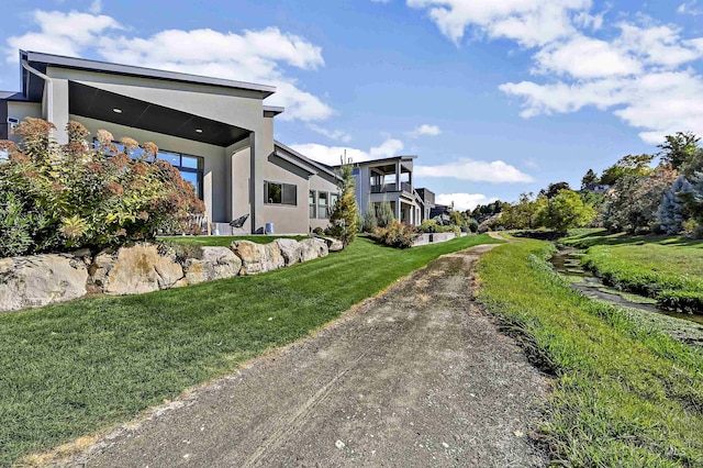 view of home's exterior featuring stucco siding and a lawn