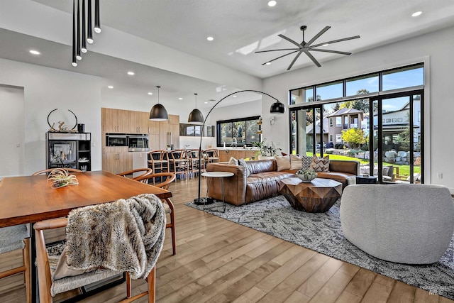 living room with recessed lighting, light wood-style floors, and ceiling fan