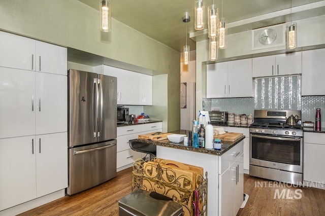 kitchen featuring light hardwood / wood-style flooring, white cabinetry, stainless steel appliances, a center island, and decorative light fixtures