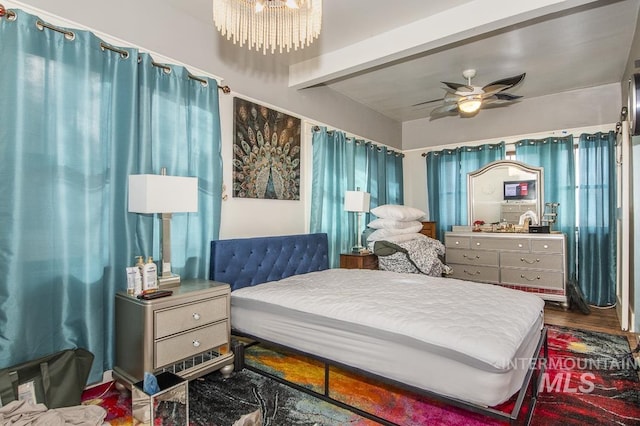 bedroom with wood-type flooring, ceiling fan with notable chandelier, and beam ceiling