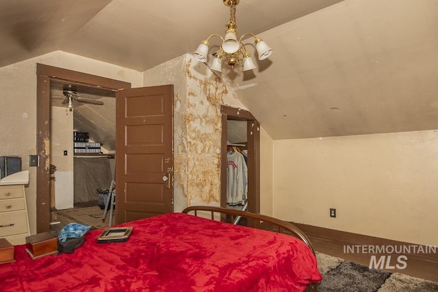 bedroom with lofted ceiling and a notable chandelier