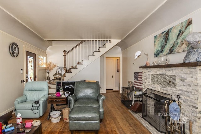 living room with hardwood / wood-style flooring and a stone fireplace