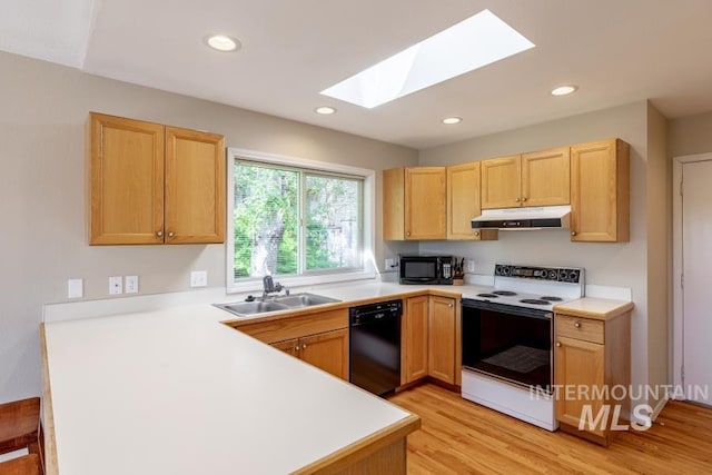 943 Colt Rd, Moscow, ID 83843 - kitchen featuring black appliances, under cabinet range hood, a sink, a skylight, and a peninsula