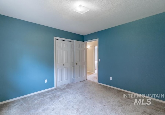 943 Colt Rd, Moscow, ID 83843 - unfurnished bedroom with carpet flooring, a closet, baseboards, and a textured ceiling