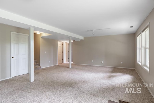 943 Colt Rd, Moscow, ID 83843 - unfurnished living room with rail lighting, carpet flooring, stairway, and baseboards