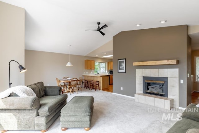 943 Colt Rd, Moscow, ID 83843 - living room featuring lofted ceiling, a ceiling fan, a fireplace, light carpet, and baseboards