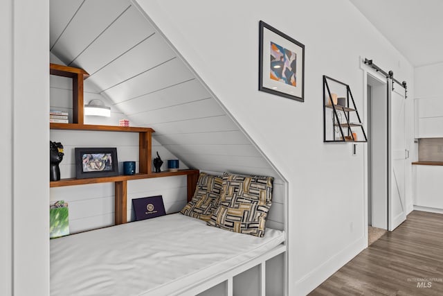 bedroom featuring wood finished floors, a barn door, baseboards, wood ceiling, and vaulted ceiling