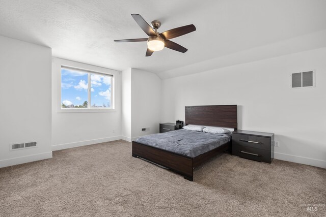 carpeted bedroom featuring visible vents, baseboards, a textured ceiling, and vaulted ceiling