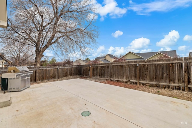 view of patio with area for grilling and a fenced backyard