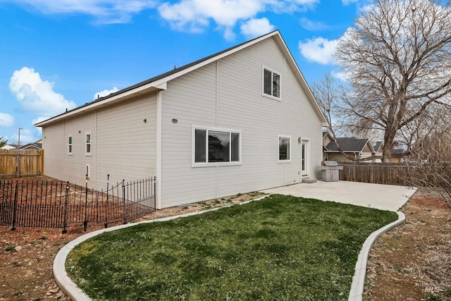 rear view of house with a patio area, a lawn, and a fenced backyard